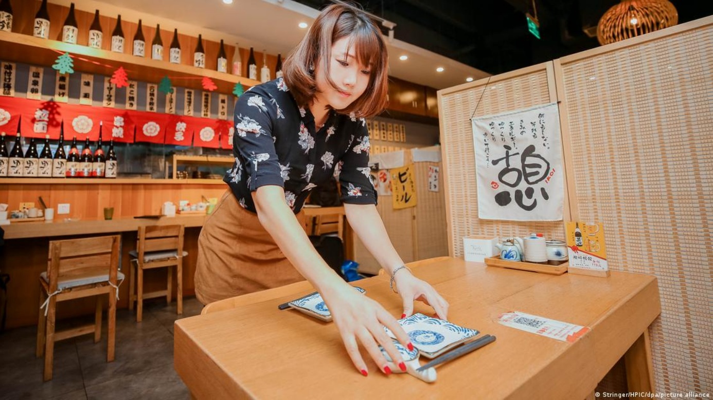 北京三里屯一家日式拉面馆的店主在整理餐桌北京三里屯一家日式拉面馆的店主在整理餐桌 ...